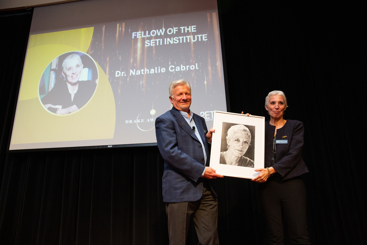 Bill Diamond presenting Nathalie Cabrol her portrait. Image Credit: SETI Institute.