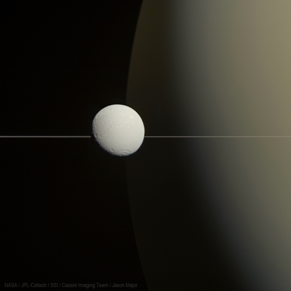 Image of a small white moon passing by a big beige planet