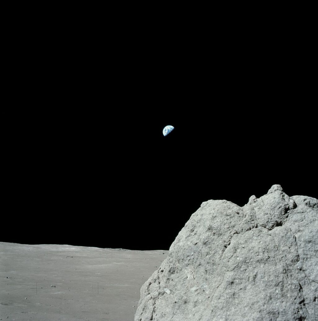 image from the rocky gray surface of the moon with the Earth off in the distance