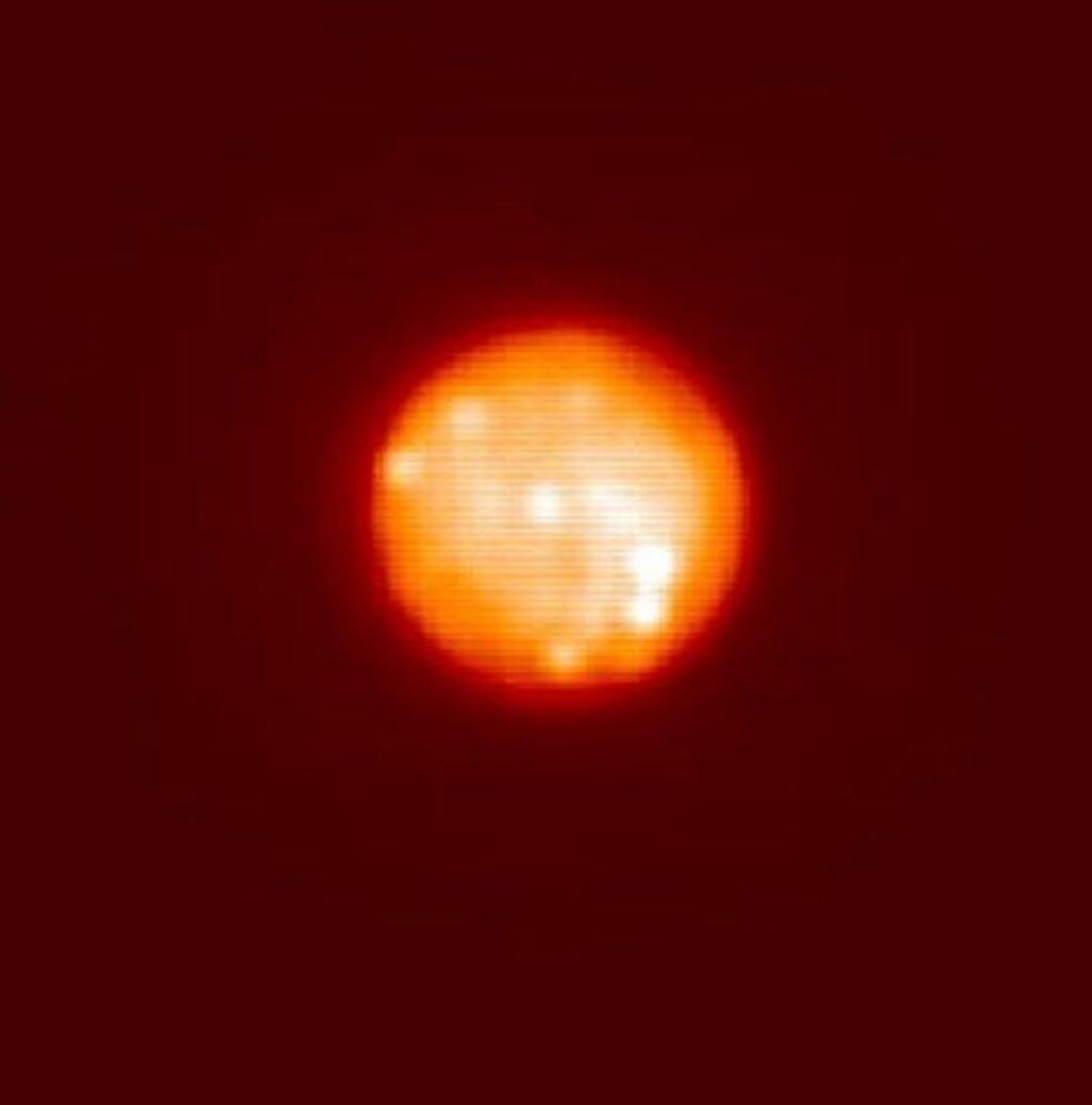Blurry and orange distant image of Io