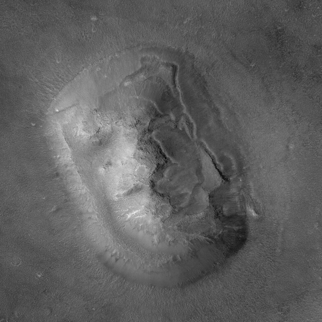Black and white image of a rock on mars shaped like a human face