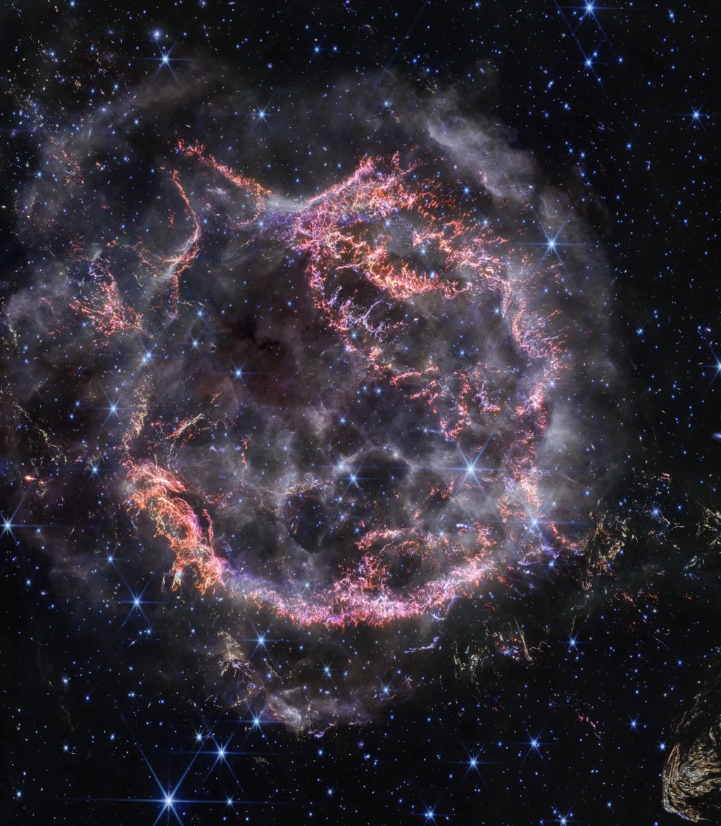 ball of dust with exploding colors of pinks, reds, and purples.