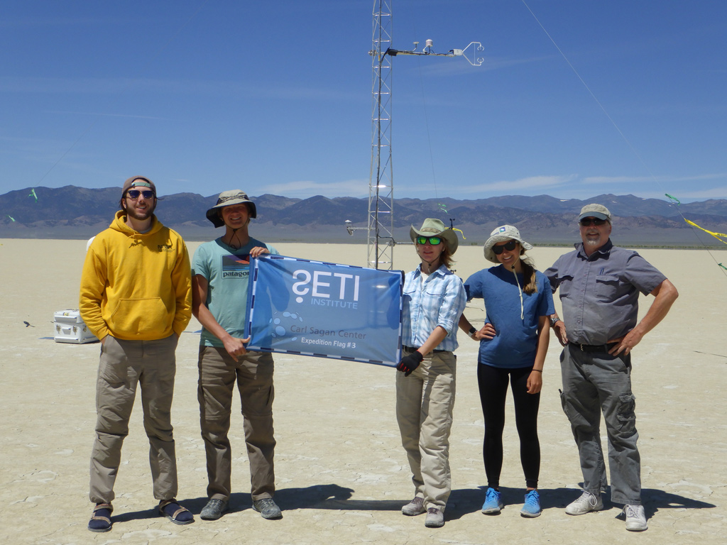 Research team posing with SETI Institute expedition flag
