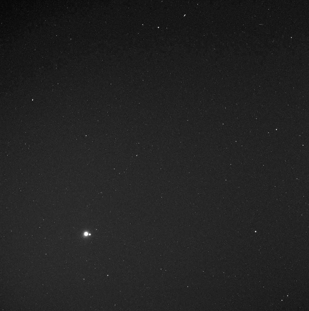Black and white image of a starfield with 2 slightly bigger and brighter dots next to each other