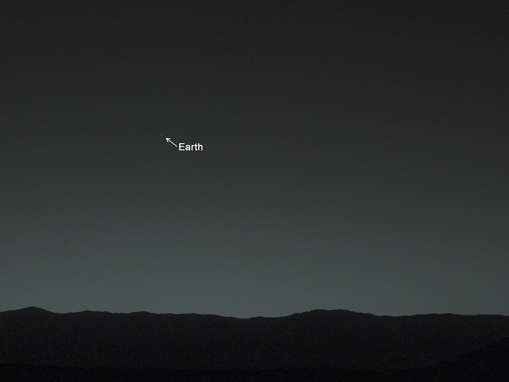 View from the surface of mars, up at the sky white a small dot pointed out as being Earth.