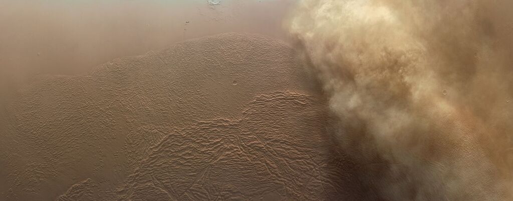 orange and brown dust storm on the surface of Mars