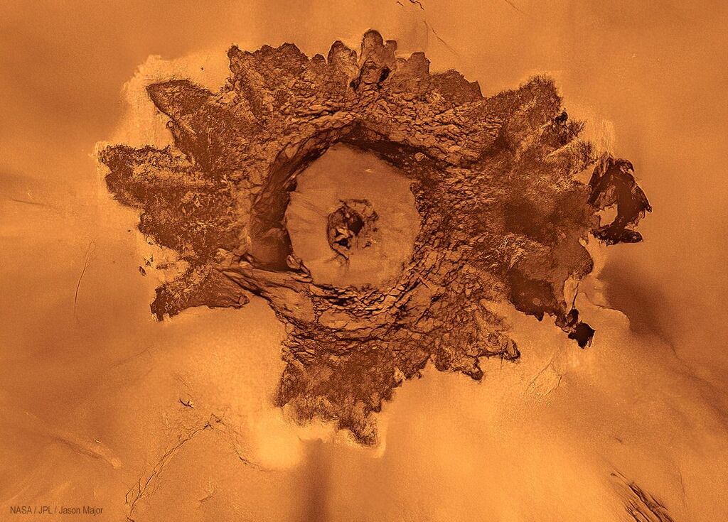 image of a brown crater on the orange surface