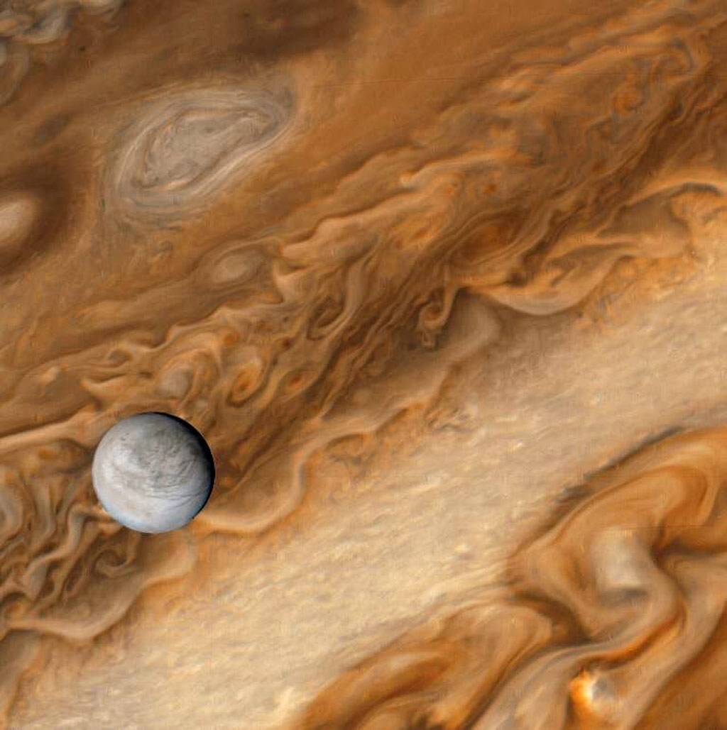 Small white moon Europa orbiting huge planet Jupiter