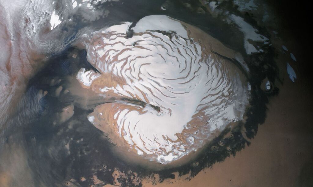 cap of white snow on top of the orange surface of mars