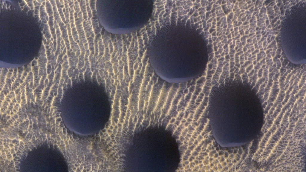 Black polka dots on the surface of Mars