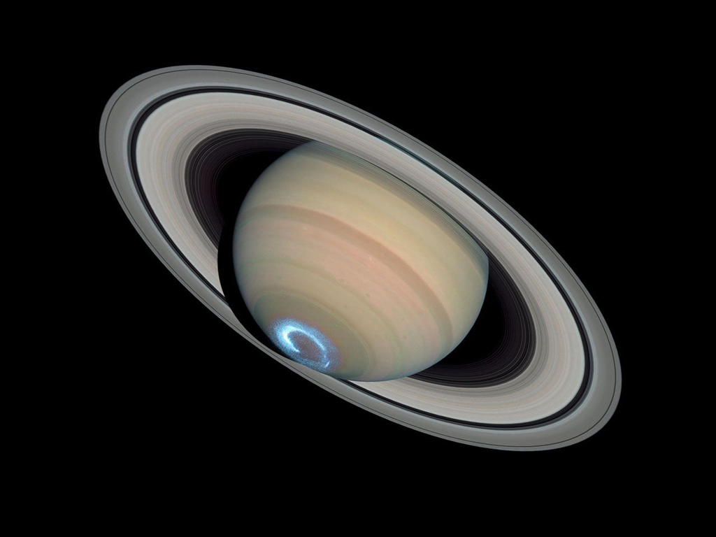 bottom view of Saturn, with a bright blue and white light shining from the bottom.