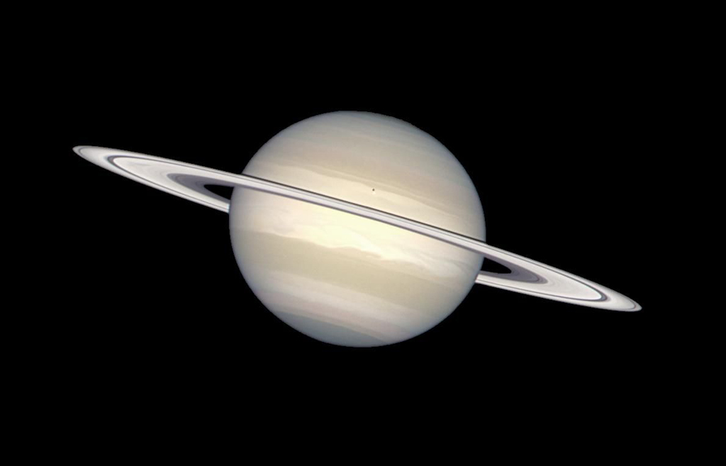 Saturn and its rings in various shades of light beige and whites