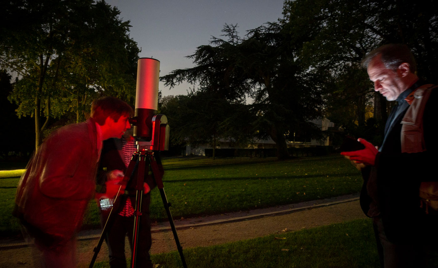 Man looking through the telescope at night.