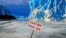 Image of Icebergs with sign In front that reads "Caution Thin Ice"