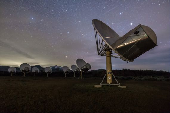 Image of the Allen Telescope Array during sunset below the night's starry sky